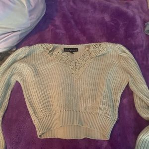 A cropped green knitted sweater
